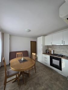 a kitchen and dining room with a table and chairs at Studio apartman Vrba in Otočac