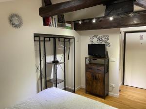 a bedroom with a bed and a television on a shelf at Appartamento - Mini Suite in Brescia