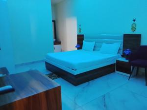a bedroom with a bed with blue lights on it at Hotel Amrindra in Kharar
