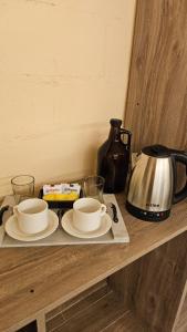 a table with two cups and a tea kettle at Andes Xtreme Hotel Boutique in Tinogasta