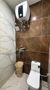 a bathroom with a toilet and a camera on the wall at Hotel Amrindra in Kharar