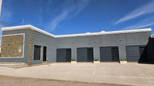a gray building with black garage doors at Andes Xtreme Hotel Boutique in Tinogasta