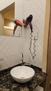 a bathroom sink with two blow dryers on the wall at Andes Xtreme Hotel Boutique in Tinogasta