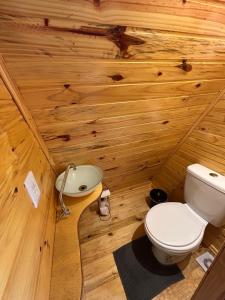 a wooden bathroom with a toilet and a sink at Texas Hill Pousada e Camping in Urubici