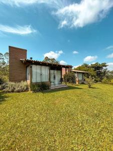 a house with a grass yard in front of it at Chalés Aconchego dos Canyons in Praia Grande