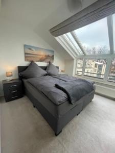 a bedroom with a bed and a large window at MeerZeit in Bad Zwischenahn