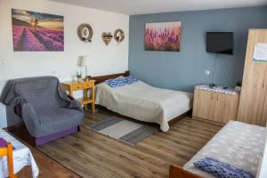 a room with two beds and a chair and a tv at Noclegi U Asi in Polańczyk