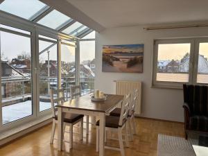 a dining room with a table and chairs and windows at MeerZeit in Bad Zwischenahn +16 photos
