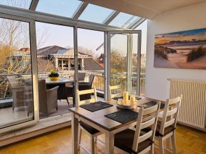 a dining room with a table and a large window at MeerZeit in Bad Zwischenahn