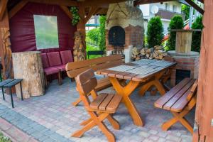 a wooden picnic table and benches on a patio at Noclegi U Asi in Polańczyk