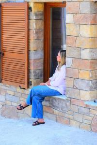 a woman sitting on a ledge of a brick wall at Villa San Martino in San-Martino-di-Lota
