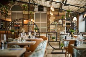 a restaurant with tables and chairs and plants at The Milner York in York