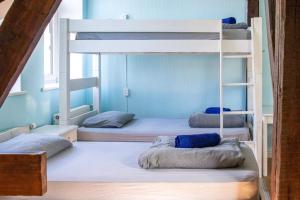 three bunk beds in a room with blue walls at Central Hostel in Riga