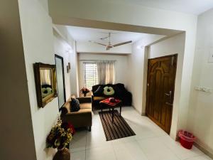 a living room with a couch and a table and a door at Gulshan Guest House in Dhaka