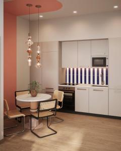 a kitchen with white cabinets and a table and chairs at Lumen Mare Malvarrosa by SH Hoteles in Valencia +8 photos