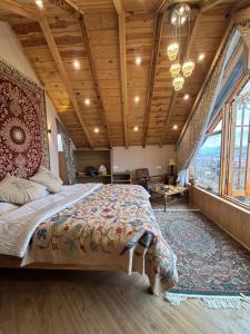 a bedroom with a large bed with a wooden ceiling at Weather cottage in Srinagar