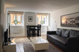 a living room with a black couch and a table at Executive Living Old Town Unique in Stockholm
