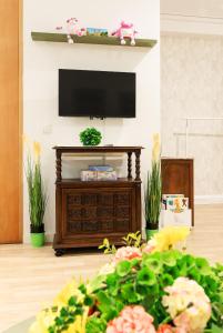 a living room with a tv and a table with flowers at Bom Braga AL in Braga