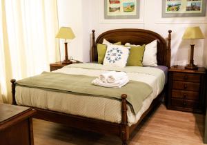 a bedroom with a bed with two night stands and two lamps at Bom Braga AL in Braga