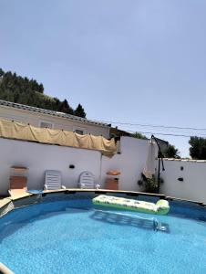a swimming pool with an inflatable raft in front of a building at Casa Valle del Hontanar in Cardenete
