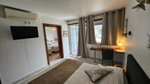 a hotel room with a bed and a desk and a mirror at Résidence Hôtelière La Farguaise 3min du péage in Fargues-de-Langon