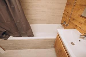 a bathroom with a tub and a sink and a shower at 2 кім кв BIG APARTMENT TOP Center in Sumy +7 photos