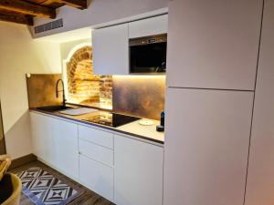 a kitchen with white cabinets and a microwave at Il Rivellino in Marostica