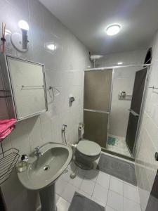 a bathroom with a toilet and a sink and a shower at Casa com 2 suítes com ar in Cabo Frio +9 photos
