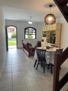 a kitchen and living room with a table and chairs at Casa com 2 suítes com ar in Cabo Frio