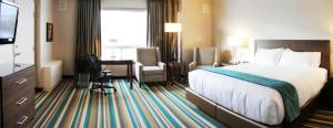 a hotel room with a bed and a desk at Hotel Blackfoot in Calgary +34 photos