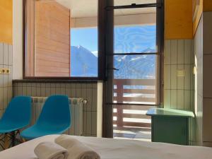 a bedroom with two blue chairs and a window at Tsar Bani Spa Resort in Gudauri