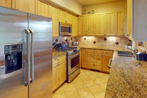 a kitchen with wooden cabinets and a stainless steel refrigerator at Urban Mountain Getaway & Alpenglow Chalet in Steamboat Springs