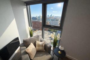 a living room with a couch and a large window at Stunning Albert Dock Penthouse in Liverpool