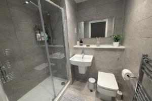 a bathroom with a shower and a toilet and a sink at Stunning Albert Dock Penthouse in Liverpool