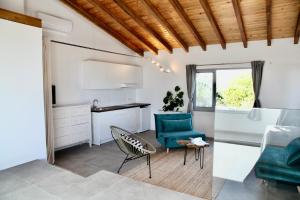 a living room with a green chair and a desk at Villa Casa Rosa in Olhão