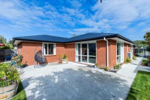 a red brick house with a blue roof at Contemporary Methven Abode in Methven