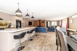 a kitchen and living room with a bar and chairs at Contemporary Methven Abode in Methven