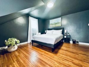 a bedroom with a large bed and a wooden floor at Central location Parking in Cheektowaga
