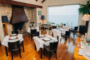 a restaurant with tables and chairs and a fireplace at Hotel Boutique Casadoca in Concón