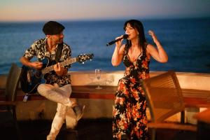 a man and a woman singing and playing guitar at Hotel Boutique Casadoca in Concón