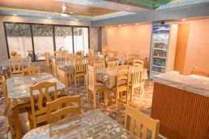 a restaurant with wooden tables and chairs and a room with windows at Arron Grand Inn in Zamboanga