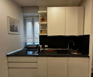 a kitchen with white cabinets and a black counter top at My Home Lainate Historic Center in Lainate +20 photos