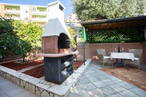 a outdoor oven in a garden with a sink at Apartmani Zlata in Rabac +2 photos