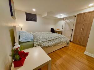 a bedroom with a bed and a table in it at Comfy Private Basement- Scarborough in Toronto