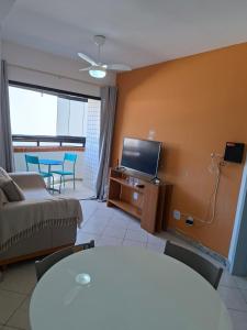 a living room with a couch and a flat screen tv at Ap Orla de Aracaju in Aracaju
