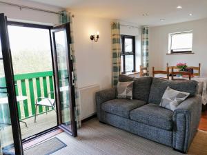 a living room with a couch and a balcony at Capstan Cottage in Whitby