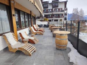 a row of chairs and tables on a patio at APPARTAMENTI LATEMAR con PISCINA e SAUNA in Cavalese