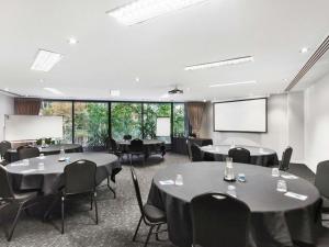 a conference room with tables and chairs and a projection screen at Mantra Southbank in Melbourne +56 photos