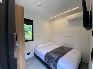 a small bedroom with a bed and a window at Hotel CLN in Copacabana