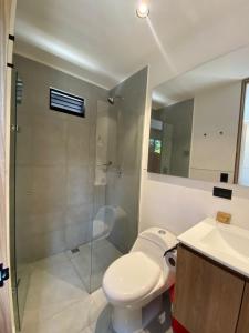 a bathroom with a toilet and a shower and a sink at Hotel CLN in Copacabana